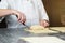 Baker makes some rolls from raw dough and filling, using special knife for dough