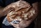 Baker man holding rustic loaf of bread in hands