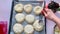 The baker prepares buns with cottage cheese.