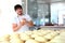 The baker prepares the tortillas dough. Yeast dough in the hands of a baker. The process of making tortillas. Horizontal photo.