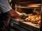 A baker removing some delicious bread from oven - Food design