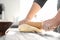 Baker rolling dough on kitchen table