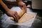 Baker`s hands roll ginger dough on a dark background. Close-up, soft focus. Side view, top view. Copy space