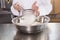 Baker sieving flour into a bowl