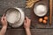 Baker sift the flour on a dark rustic wooden background