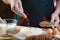 Baker sprinkle the dough with cereals bread, pizza or pie recipe ingredients with hands, food on kitchen table background, working