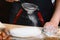 Baker sprinkle the dough with flour bread, pizza or pie recipe ingredients with hands, food on kitchen table background, working w