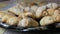 Baker sprinkles cooked fresh croissants with powdered sugar. Closeup shot of domestic home made and handmade diy bakery