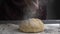 Baker sprinkling flour into dough on table