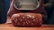 The Baker takes out fresh bread with grains on the table