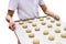 Baker with tray of balls dough for baking buns isolated