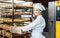 Baker woman pushing sheets with bread in the baking oven