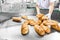 Baker worker packs bread for sale in store, food industrial production