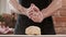 Bakers hands clap their hands filled with flour on a black background. The baker works with dough and flour. Baking