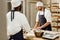 bakers kneading dough together at baking manufacture