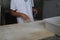 Bakers making handmade loaves of bread in a family bakery shaping the dough into tradional shapes. Working hands kneading bread