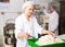 Bakers portioning dough with bench cutter at bakery