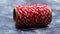 Bakers twine. Red and white lines. Red roll of woolen thread, close-up on gray marble background. Spool of decorative threads
