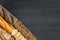 Bakery background top view. Crusty buns and loaves of bread on dark grey chalkboard background