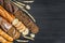 Bakery background top view. Crusty buns and loaves of bread on dark grey chalkboard background