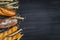 Bakery background top view. Crusty buns and loaves of bread on dark grey chalkboard background. Blurred background