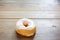 Bakery fresh doughnut soft and sweet delicious vanilla glazed frosted donut on wood table surface
