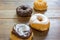 Bakery fresh doughnuts soft and sweet delicious glazed frosted donuts variety on wood table surface