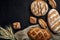 Bakery - gold rustic crusty loaves of bread and buns on black chalkboard background.