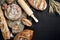 Bakery - gold rustic crusty loaves of bread and buns on black chalkboard background.