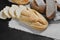 Bakery - gold rustic crusty loaves of bread on linen cloth over black chalkboard background. Flat lay,