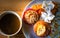 Bakery homemade, banana cupcakes with white sesame seeds and peanuts topping and fried chicken served with fresh coffee.