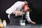 Bakery man pouring milk into a measuring jug in the kitchen at home, preparing bread dough, food homemade bakery concept