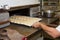 Bakery production. man, baker, placing the cakes in the oven