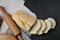 Bakery - rustic crusty loaves of bread and rolling pin on linen cloth over black chalkboard background.