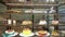 Bakery vitrine with cakes and pastries on glass shelves.