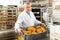 Bakery worker carrying box with loaves