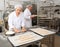 Bakery worker preparing raw baguette dough for baking