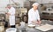 Bakery worker preparing raw baguette dough for baking