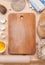 Baking background with cutting board, eggshell, flour, rolling p
