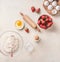Baking background with flour, eggs,rolling pin and  strawberries on white kitchen desk background, top view. Flat lay. Sweet food
