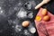 Baking background with flour, rolling pin, eggs, and heart shape on kitchen black table top view for Valentines day cooking.