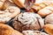 Baking close-up. Appetizing buns sprinkled with flour on a black wooden table. Bakery products