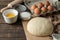 Baking ingredients. baking tools. dough and butter, eggs, sugar, milk on a brown wooden background