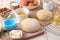 Baking ingredients. baking tools. dough and butter, eggs, sugar, milk, cinnamon, almonds on a white wooden background