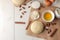 Baking ingredients. baking tools. dough with butter, eggs, sugar, milk, cinnamon, almonds on a white wooden background. view from