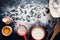 Baking ingredients on a dark, stone table: eggs, flour and milk