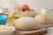 Baking ingredients. dough closeup and butter, eggs, sugar, milk, cinnamon, almonds on a white wooden background