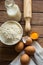 Baking ingredients flour, eggs, open yolk, milk, rolling pin, linen towel, rustic kitchen interior, utensils