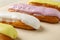 Baking paper with tasty eclairs with custard