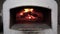 Baking pizza in an open firewood oven. Burning wood of a stone oven in a pizzeria. Prepare traditional Italian pizza